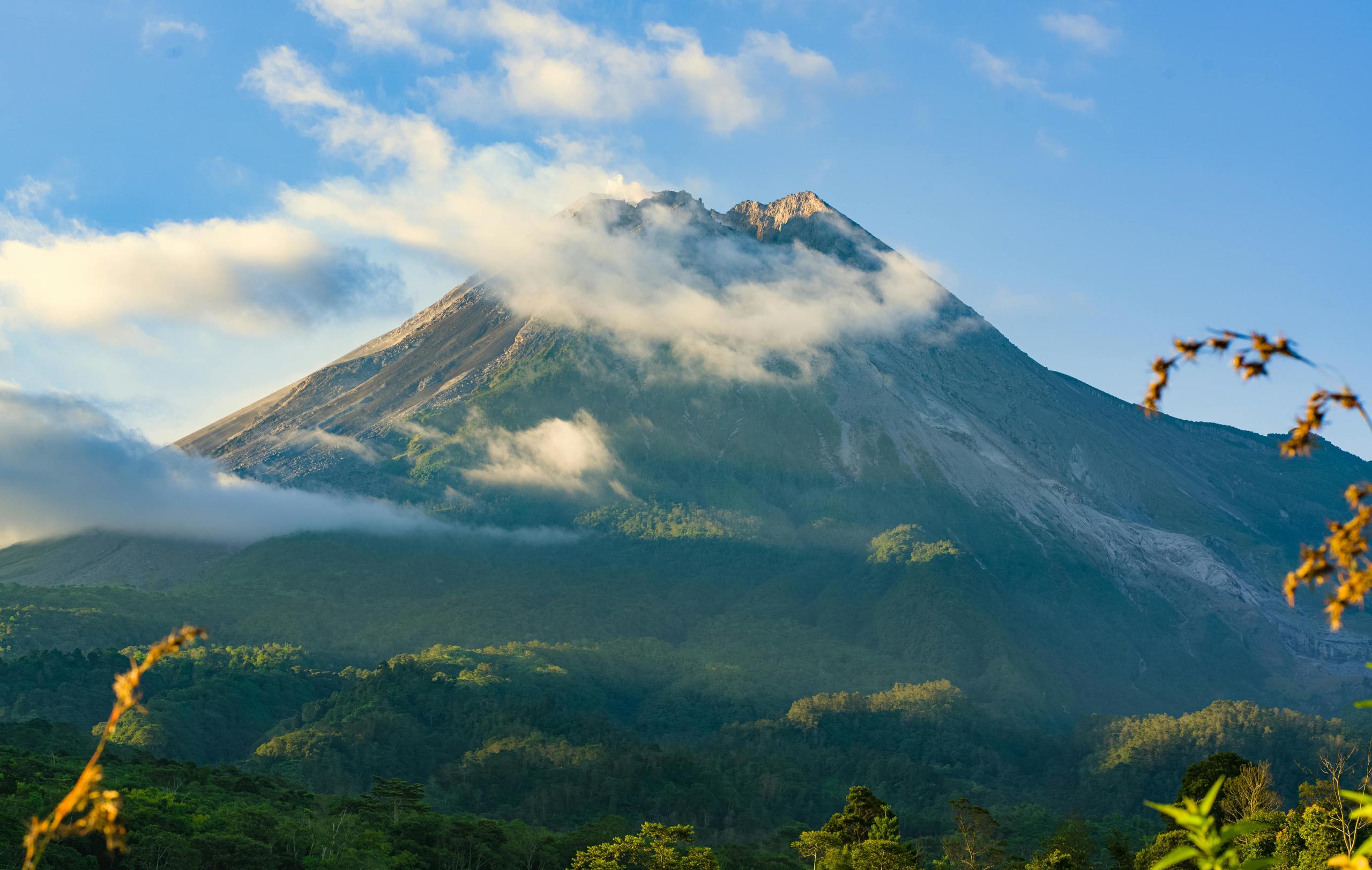 Foto van de Merapi vulkaan in Indonesië, omgeven door enkele wolken.