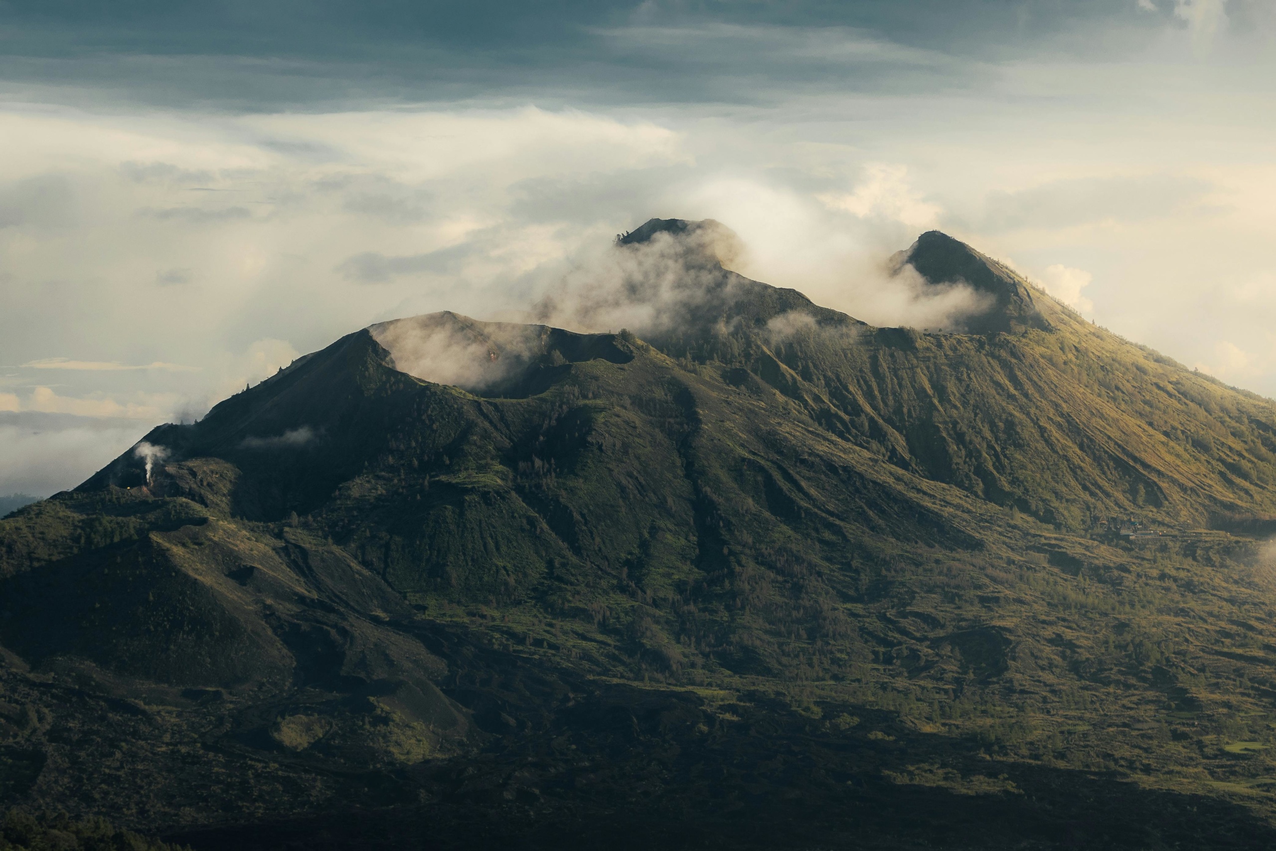 Luchtfoto van vulkaan kraters in Bali Indonesië. De foto toont een landschap van bovenaf gezien met 2 vulkaankraters omgeven door enkele wolken.