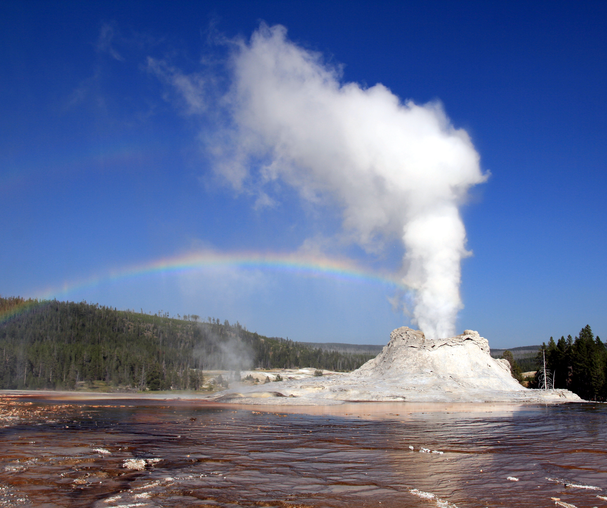Foto van een stoomeruptie van de kasteelgeiser (Castle Geyser) in Yellowstone National Park.