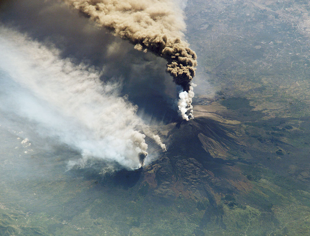 Bij uitbarsting van de vulkaan Etna in 2002-2003 werd veel vulkanische as de lucht in geslingerd. Deze foto (gemaakt in 2002) toont deze eruptie van Etna vanuit het internationale ruimtestation ISS.