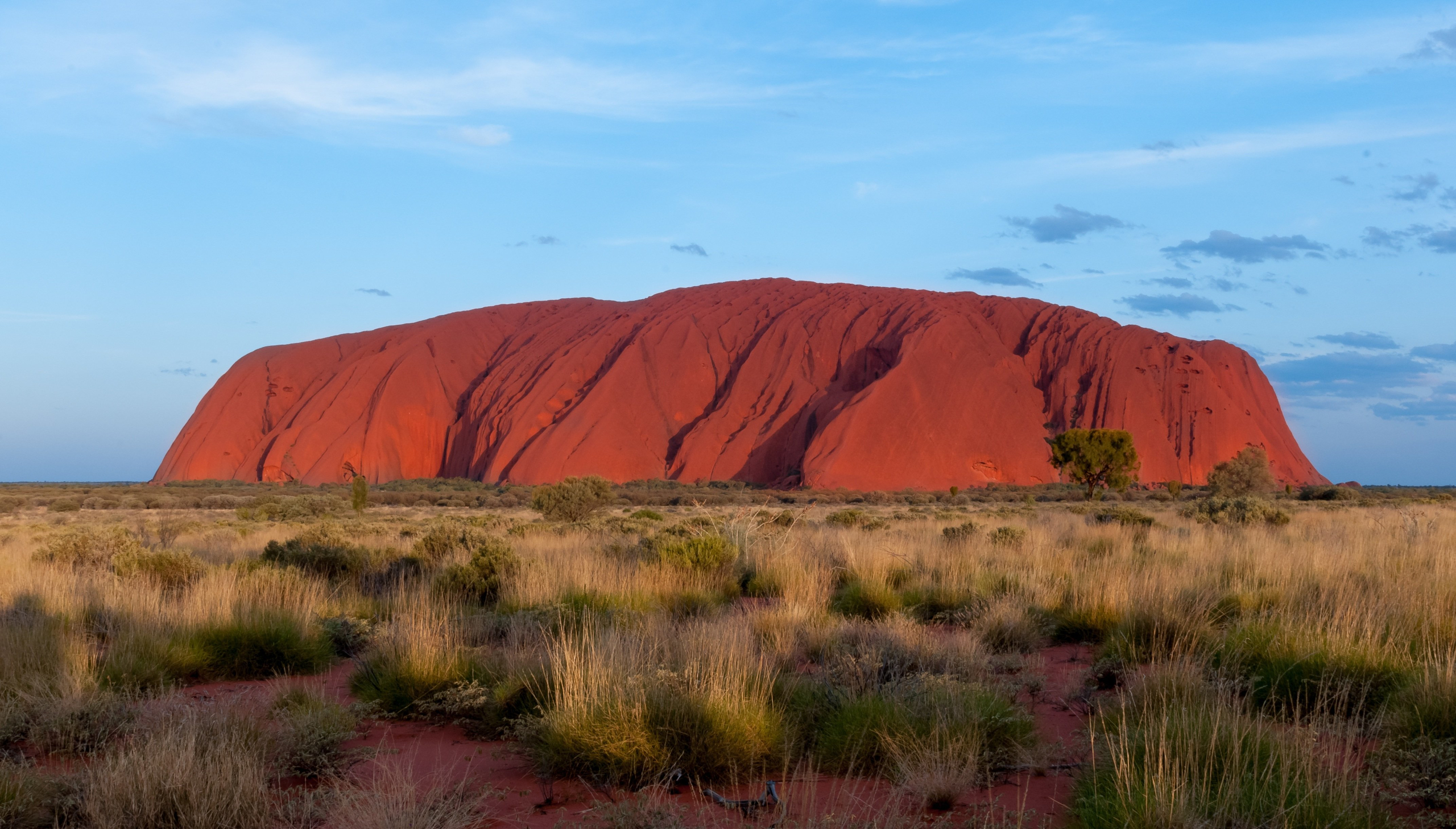 Foto van Uluru (Ayers Rock), Australië. De rode kleur is ontstaan door roesting van het ijzerrijke gesteente.